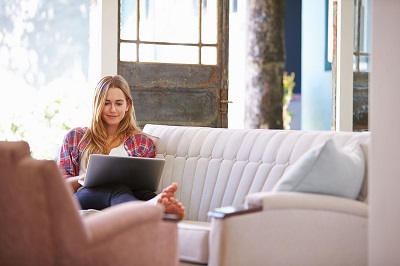 woman relaxing on couch with laptop
