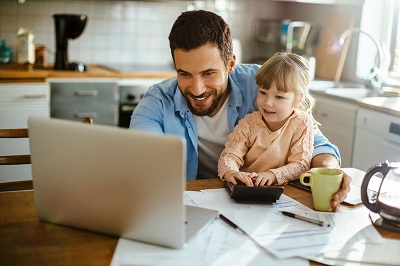 man sitting at a laptop with toddler