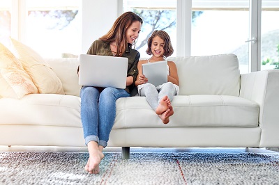 mother and daughter on sofa with laptop